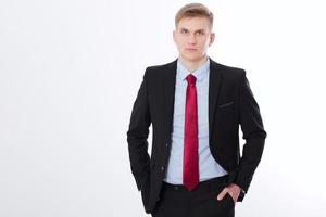 Serious businessman in black suit and red tie isolated on white background. Business concept. Copy space and mock up photo