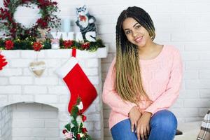 Happy teen woman in christmas home, christmas decoration three and fire place, celebration photo