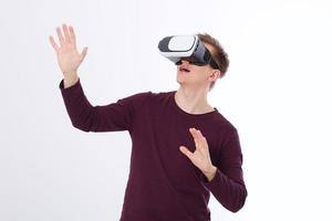 Excited young man in a VR headset, glasses. Virtual reality isolated on white background. Copy space and mock up photo