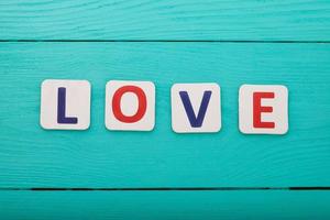 palabra amor sobre fondo de madera azul. vista superior foto