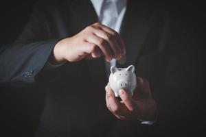 Businessman in suit is holding piggy bank. Finance Savings concept. photo