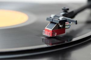 Closeup of vintage record player while playing a vinyl record. Black platter photo