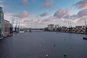 Port cranes with cityscape alongside river thames at royal victoria dock photo