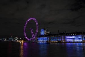The London Eye on the South Bank of the River Thames at night in London