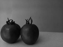 Photo of two tomatoes in black and white style. Monochrome photo.