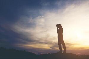 Silhouette of woman praying with god photo