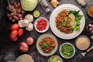 Spicy minced pork salad with chili flakes, lime, chopped green onions, chilli and roasted rice. photo