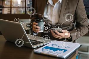 Businessman using mobile phone and laptop computer with business intelligence concept. with VR icon photo