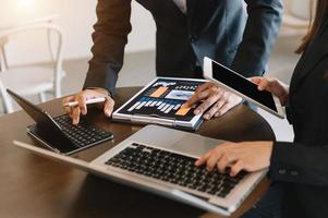 Business documents on office table with smart phone and calculator digital tablet and graph business with social network diagram and two colleagues discussing data working photo