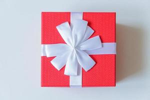 navidad año nuevo cumpleaños san valentín celebración presente concepto romántico. caja de regalo roja de diseño simplemente minimalista aislada sobre fondo blanco. espacio de copia de vista superior plana. foto