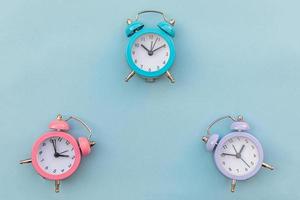 Simply minimal design three ringing twin bell classic alarm clock Isolated on blue pastel background. Rest hours time of life good morning night wake up awake concept. Flat lay top view copy space. photo