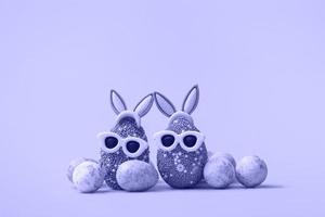 Colorful Easter egg with bunny ears and sunglasses on a very peri background. Sale banner, mockup template. copy space photo