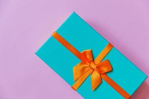 navidad año nuevo cumpleaños san valentín celebración presente concepto romántico. caja de regalo azul de diseño simplemente minimalista aislada sobre fondo violeta violeta. vista superior plana, espacio de copia foto