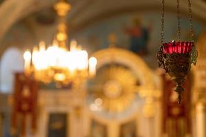 Iglesia Ortodoxa. cristiandad. decoración interior festiva con velas encendidas e icono en la iglesia ortodoxa tradicional en vísperas de pascua o navidad. religión fe orar símbolo. foto