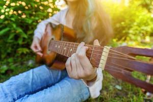 Woman hands playing acoustic guitar photo