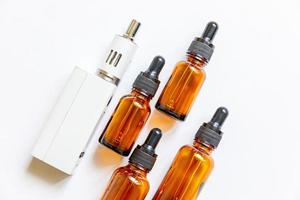 Vaping device e-cigarette electronic cigarette and liquid bottles isolated on white background. Vape device for alternative smoking. Vaping shop concept. Gadget for vaper. Vaping accessories. photo