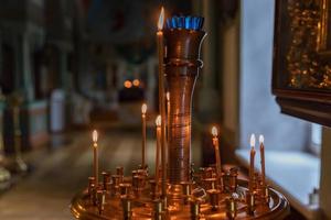 Iglesia Ortodoxa. cristiandad. decoración interior festiva con velas encendidas e icono en la iglesia ortodoxa tradicional en vísperas de pascua o navidad. religión fe orar símbolo. foto