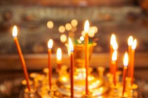 Iglesia Ortodoxa. cristiandad. decoración interior festiva con velas encendidas en la iglesia ortodoxa tradicional en vísperas de pascua o navidad. religión fe orar símbolo. foto