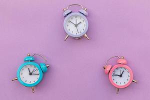 Simply minimal design three ringing twin bell classic alarm clock Isolated on purple violet background. Rest hours time of life good morning night wake up awake concept. Flat lay top view copy space. photo