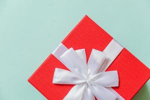 navidad año nuevo cumpleaños san valentín celebración presente concepto romántico. Caja de regalo roja de diseño simplemente minimalista aislada sobre fondo azul pastel. vista superior plana, espacio de copia foto