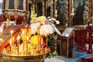 Iglesia Ortodoxa. cristiandad. decoración interior festiva con velas encendidas e icono en la iglesia ortodoxa tradicional en vísperas de pascua o navidad. religión fe orar símbolo. foto