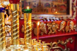 Iglesia Ortodoxa. cristiandad. decoración interior festiva con velas encendidas e icono en la iglesia ortodoxa tradicional en vísperas de pascua o navidad. religión fe orar símbolo. foto