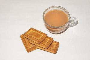 concepto de desayuno matutino. taza de té y galletas sobre fondo blanco. foto