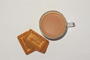 concepto de desayuno matutino. taza de té y galletas sobre fondo blanco. foto