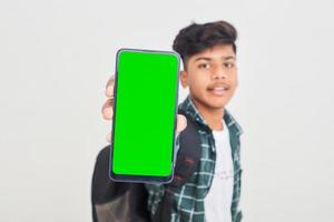 Young indian college student showing smartphone Screen on white background. photo