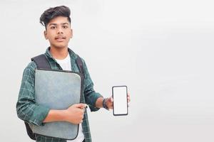 Young indian student holding file and showing smartphone screen on white background. photo