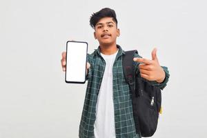 Indian college student showing mobile screen on white background. photo