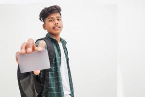 Young indian man showing debit or credit card on white background. photo