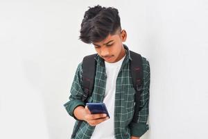 Indian college student using smartphone on white background. photo