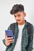 Indian college student using smartphone on white background. photo