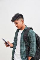 Indian college student using smartphone on white background. photo