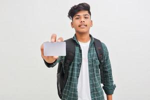 Young indian man showing debit or credit card on white background. photo