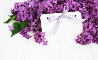 Lilac flowers with greeting card on a table photo