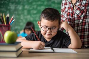 niño escribe un libro en el aula. foto