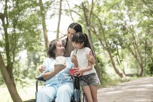 Granddaughter have surprise to grandmother sitting on wheelchair. photo