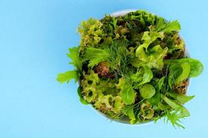 Bowl of mixed salad on bright, color background. photo