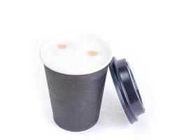 vaso de papel negro desechable con capuchino, café con leche. foto