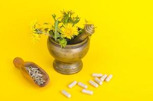 hierbas en mortero y medicinas modernas, hierbas medicinales en cápsulas. foto