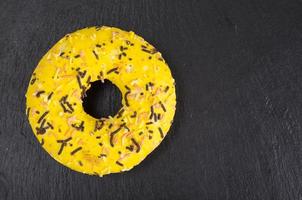 Homemade donuts with colored icing on black background. photo