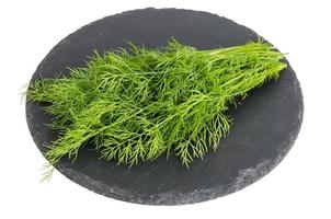 Bunch of fresh green dill on black stone. photo