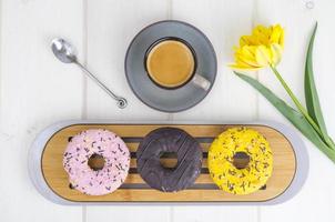Espresso, sweet donuts with colorful icing. photo