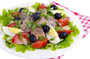 Salad of fresh vegetables, egg, canned fish and olives. photo