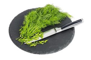 Bunch of fresh green dill on black stone. photo