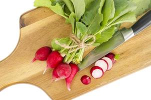 Bunch of fresh red radish on wooden cutting board for cooking. photo