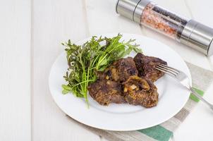 Fried beef liver with lettuce mix. photo