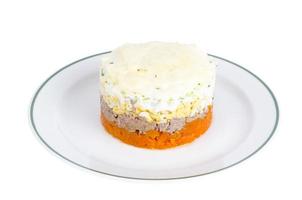 Portion layered salad with fish, carrots and eggs. photo